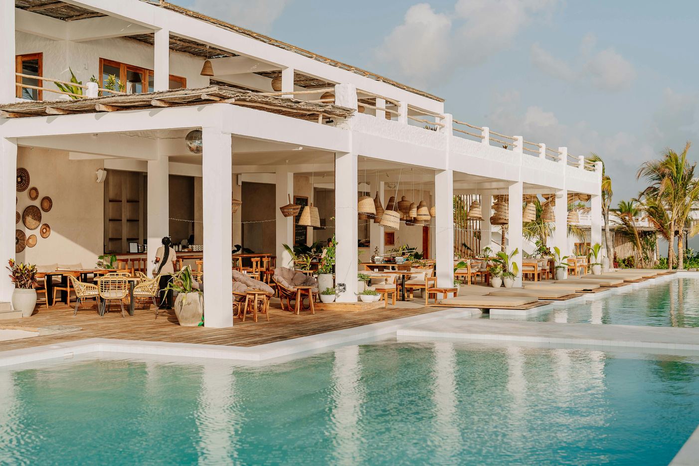 A white colonnaded resort beside a still pool